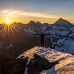 person standing on cliff during golden hour