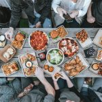 a group of people sitting around a table with food