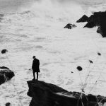man in black shirt standing on snow covered ground
