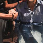 a man sitting at a table with his hand on his face