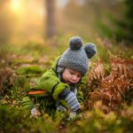 selective focus photo of baby on green grass field