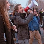 a man with long hair holding a red and white megaphone