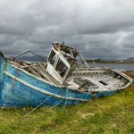 blue and white boat on green grass field during daytime
