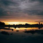 The sun is setting over a body of water