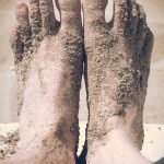 closeup photo of person's feet covered with sand