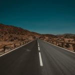 an empty road in the middle of a desert