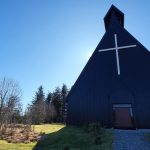 a black church with a cross on the top of it