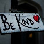 a sign that says be kind on it
