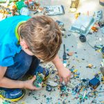 boy sitting while holding electronic device part