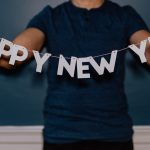 person holding happy new year decor