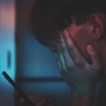 man holding smartphone in close up photography