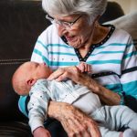 an older woman holding a baby