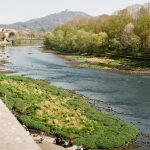 a group of people sitting next to a river