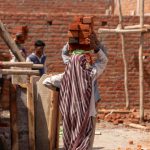 woman carrying bricks on her head