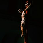 a statue of a man on a cross in the dark